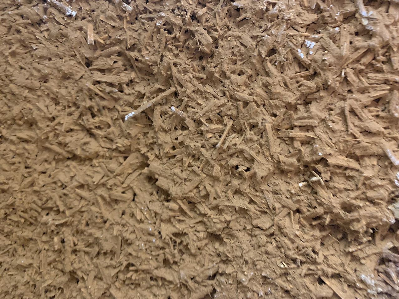 Gros plan sur la face extérieure d’un mur en pisé, terre tassée